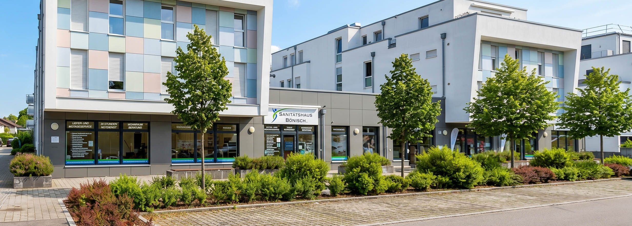 headeraboutus-sani-bönisch-olching2 Das Foto zeigt einen Messestand in einer hellen Halle, an dem ein Treppenlift präsentiert wird. Eine junge Frau sitzt lächelnd auf dem weißen Treppenliftsitz, während ein Mann im schwarzen Anzug daneben steht und ein weiterer Mann im Hintergrund an einem runden Informationstisch sitzt. Der Stand ist mit Teppichen und verschiedenen Informationsmaterialien ausgestattet, um die Funktionsweise der Mobilitätshilfe für Interessierte zu veranschaulichen.